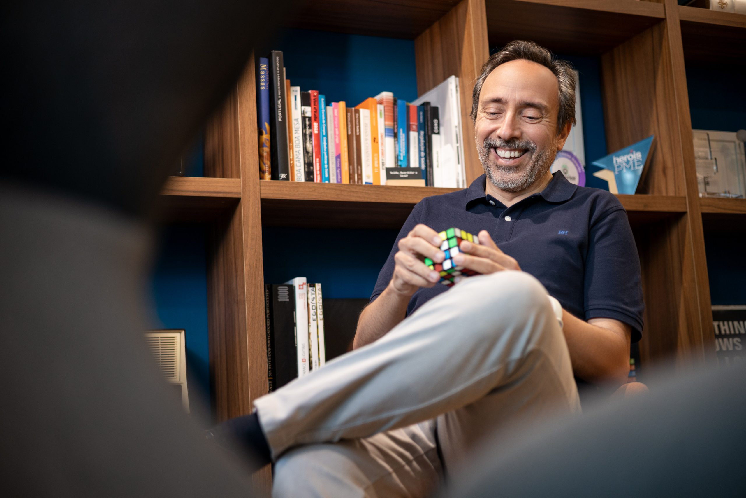 Massimo Forte, influenciador do mercado imobiliário, sentado em sua biblioteca a brincar com um cubo de Rubrik