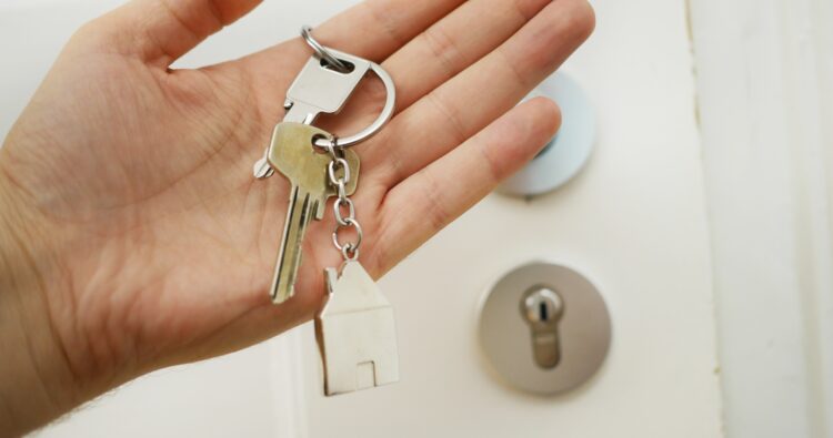 Mãos de um inquilino segurando as chaves do apartamento que arrendou